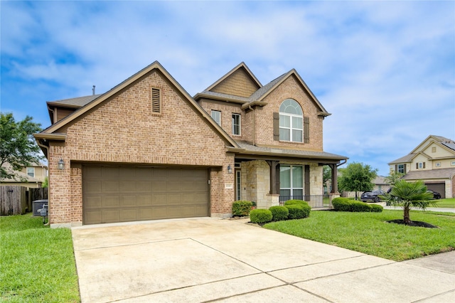 view of front of house with an attached garage, a porch, a front yard, and concrete driveway