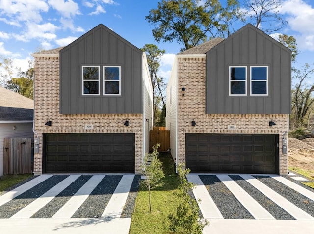 view of front of home with board and batten siding, an attached garage, and brick siding