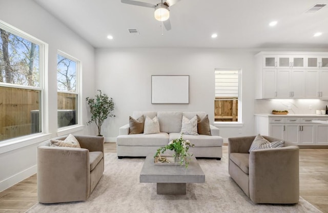 living area featuring light wood finished floors, visible vents, and recessed lighting