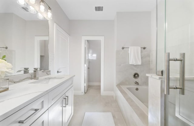 full bathroom featuring vanity, a relaxing tiled tub, walk in shower, baseboards, and visible vents