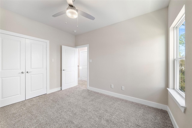 unfurnished bedroom with baseboards, carpet floors, a closet, and ceiling fan