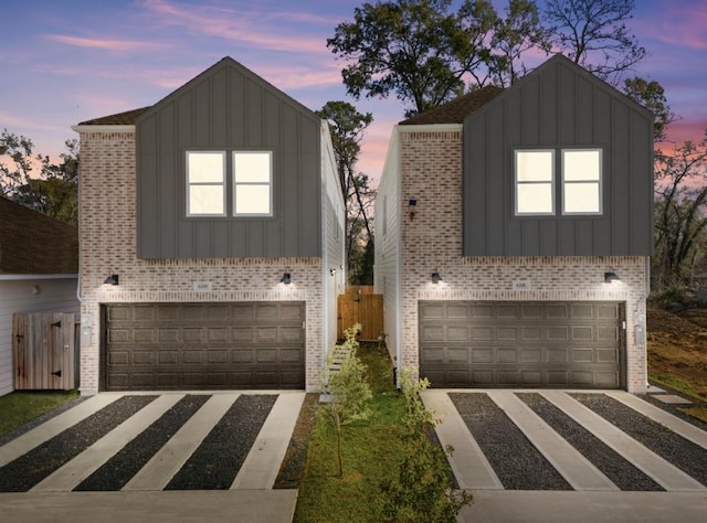 view of front of property with board and batten siding, brick siding, and a garage