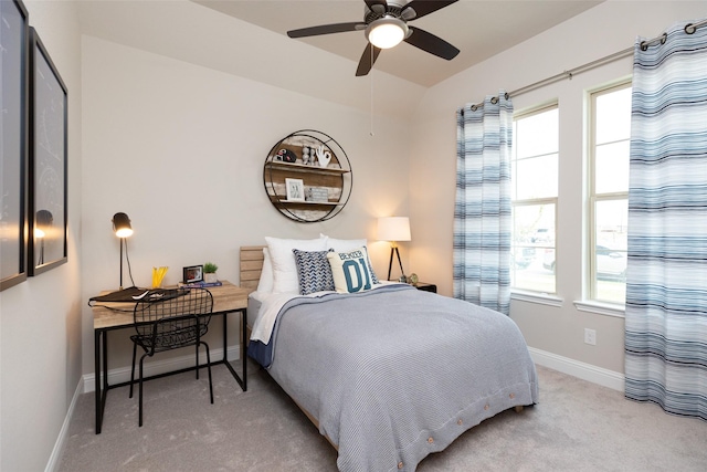 carpeted bedroom featuring baseboards and multiple windows