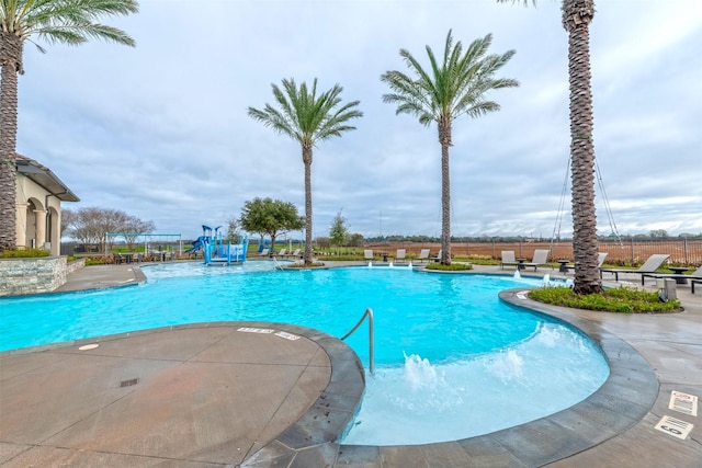 community pool with fence and a patio area