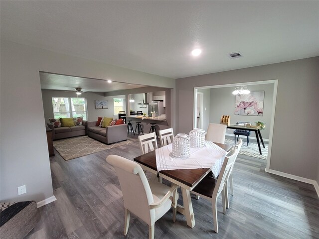 10654 Mayfield Rd, Houston, TX 77043 - dining space with baseboards, a chandelier, wood finished floors, and visible vents