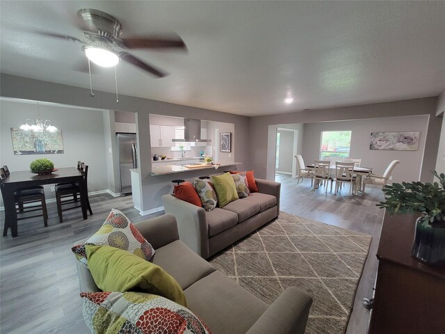 10654 Mayfield Rd, Houston, TX 77043 - living room featuring baseboards, wood finished floors, and ceiling fan with notable chandelier