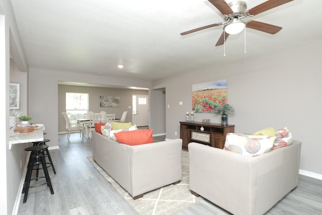10654 Mayfield Rd, Houston, TX 77043 - living room featuring light wood-style flooring, baseboards, and a ceiling fan