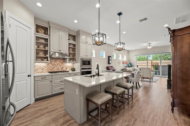 kitchen with stainless steel appliances, open floor plan, visible vents, and a sink