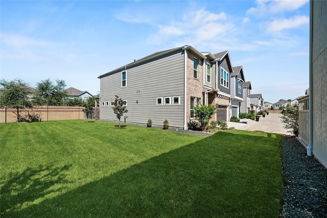 exterior space with an attached garage, fence, a yard, and a residential view