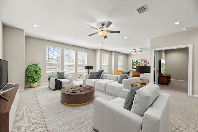 living room with carpet floors, baseboards, a ceiling fan, and visible vents