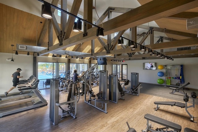 workout area featuring high vaulted ceiling, visible vents, and wood finished floors
