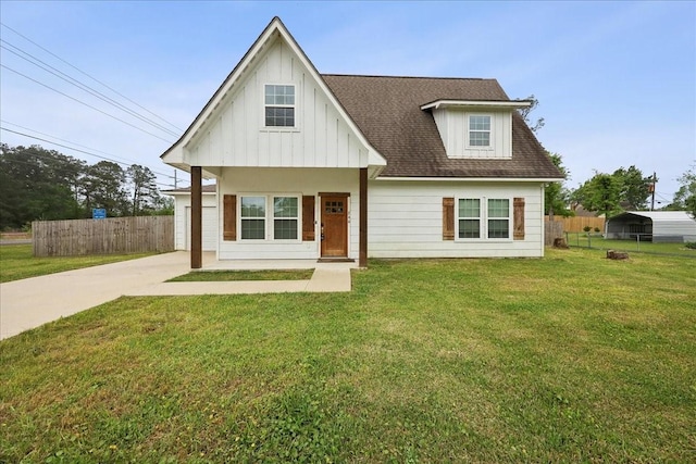 view of front of property with concrete driveway, a shingled roof, a front yard, and fence