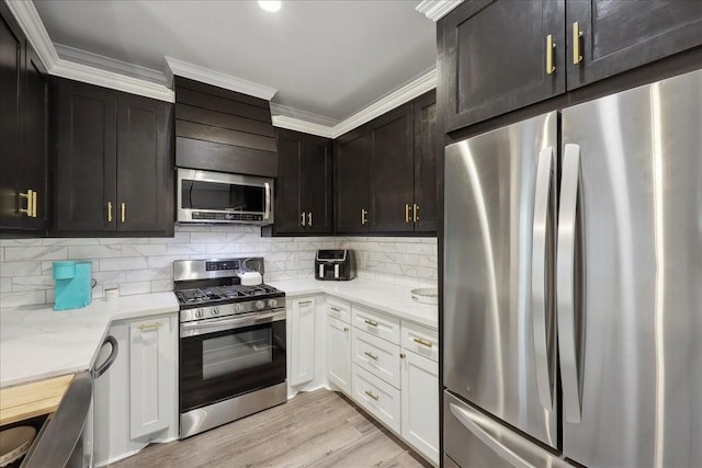 kitchen featuring ornamental molding, decorative backsplash, light wood finished floors, and stainless steel appliances