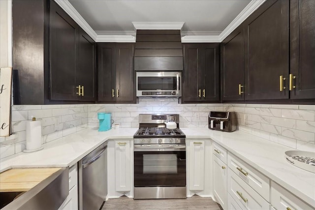 kitchen with backsplash, light stone counters, stainless steel appliances, and white cabinets