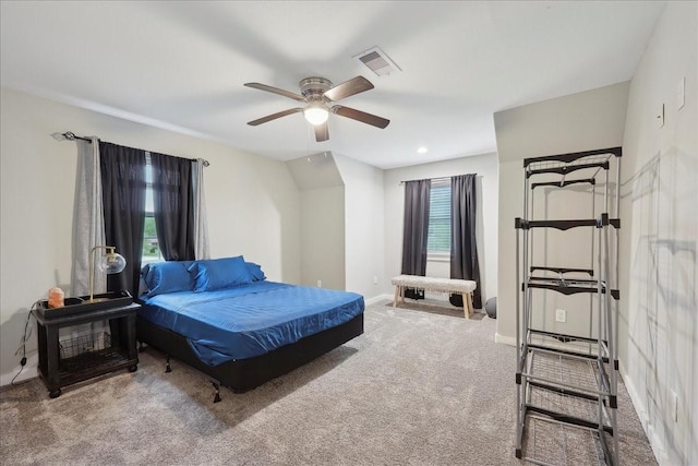 carpeted bedroom featuring baseboards, a ceiling fan, and visible vents
