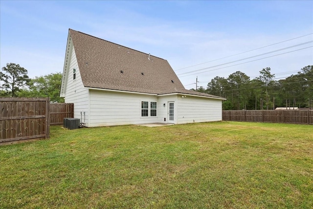 rear view of house featuring a fenced backyard, central AC unit, a patio area, a shingled roof, and a yard