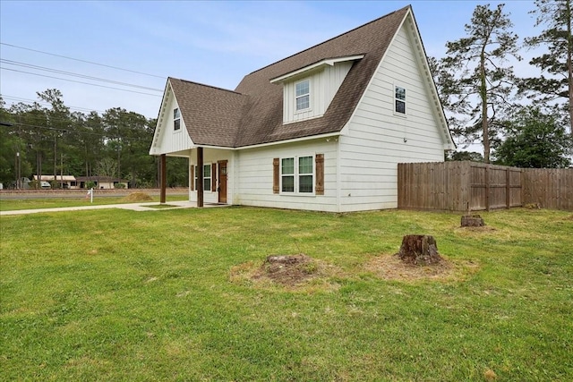 view of front of home featuring fence, a shingled roof, and a front yard