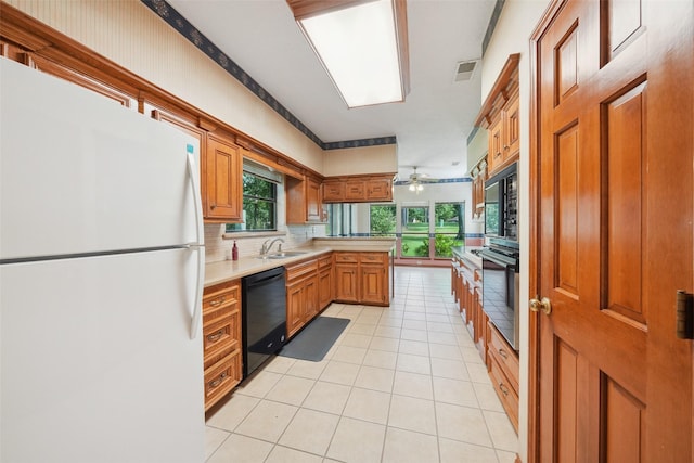 12 Cherry Hill Dr, Conroe, TX 77304 - kitchen featuring black appliances, a sink, light countertops, light tile patterned floors, and tasteful backsplash