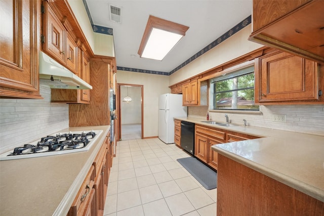 12 Cherry Hill Dr, Conroe, TX 77304 - kitchen featuring under cabinet range hood, white appliances, light countertops, light tile patterned flooring, and backsplash