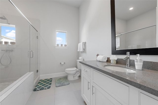 bathroom with a shower stall, vanity, baseboards, toilet, and tile patterned flooring