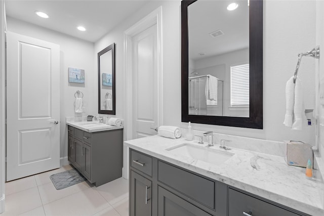 full bathroom featuring two vanities, visible vents, tile patterned flooring, and a sink