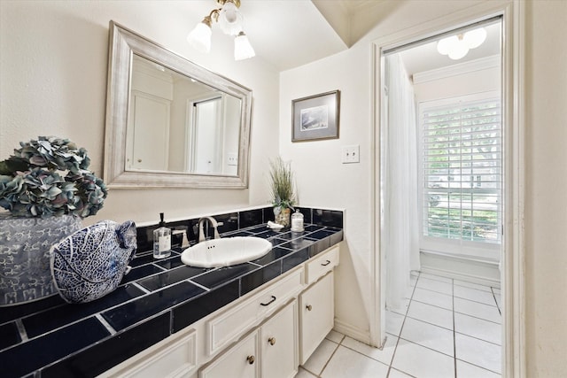 bathroom with ornamental molding, tile patterned flooring, vanity, and baseboards