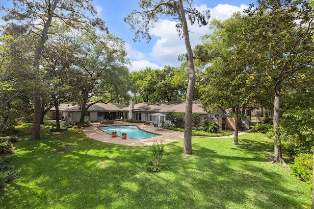 pool featuring a lawn and a patio area