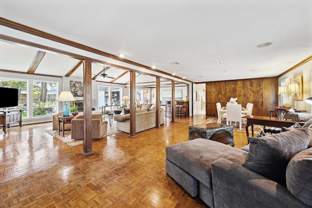 living area with wood walls and ornamental molding