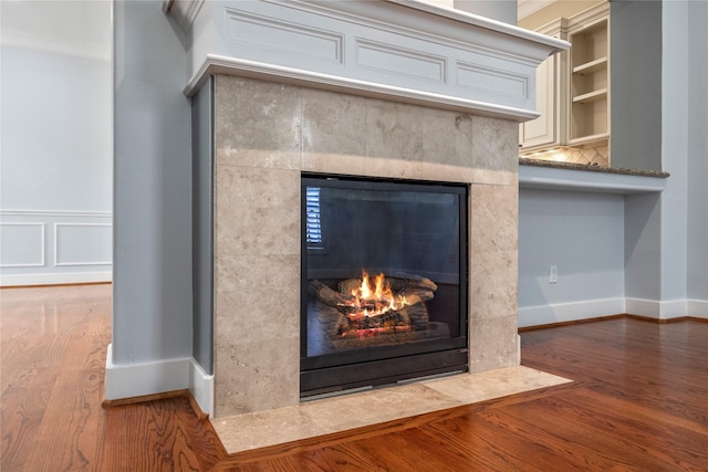 details with a fireplace, wood finished floors, crown molding, and baseboards