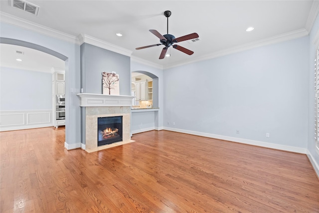 unfurnished living room featuring a ceiling fan, wood finished floors, a tiled fireplace, visible vents, and recessed lighting