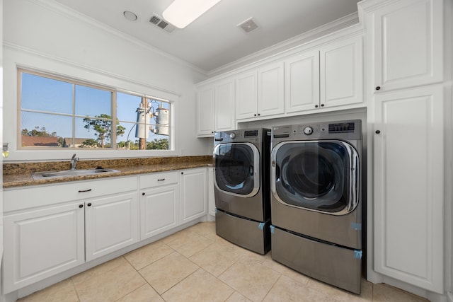 clothes washing area featuring washer and clothes dryer, visible vents, ornamental molding, a sink, and cabinet space