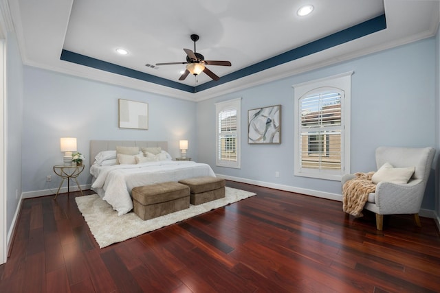 bedroom featuring hardwood / wood-style flooring, baseboards, a raised ceiling, and crown molding