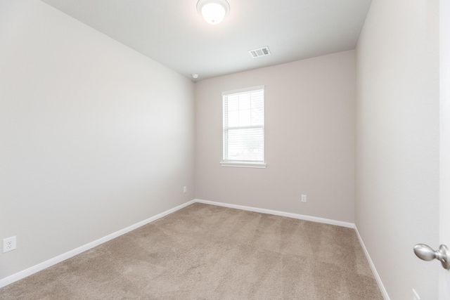 unfurnished room with light colored carpet, baseboards, and visible vents