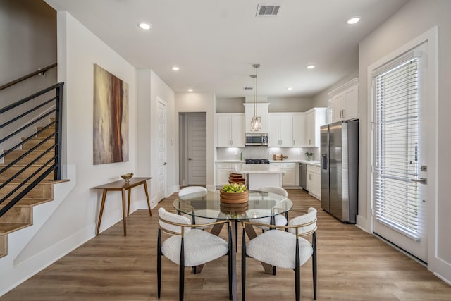 8411 Pech Landing Dr, Houston, TX 77055 - dining area with stairs, baseboards, light wood-style flooring, and recessed lighting