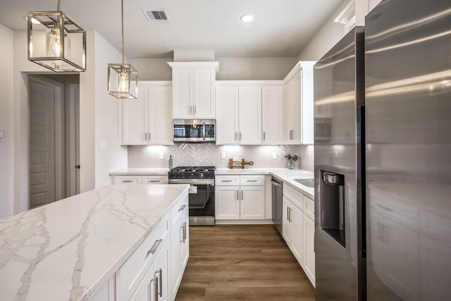 8411 Pech Landing Dr, Houston, TX 77055 - kitchen featuring appliances with stainless steel finishes, white cabinetry, dark wood-style floors, backsplash, and recessed lighting