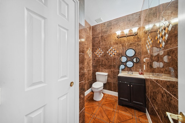 bathroom with toilet, tile walls, visible vents, tile patterned flooring, and vanity