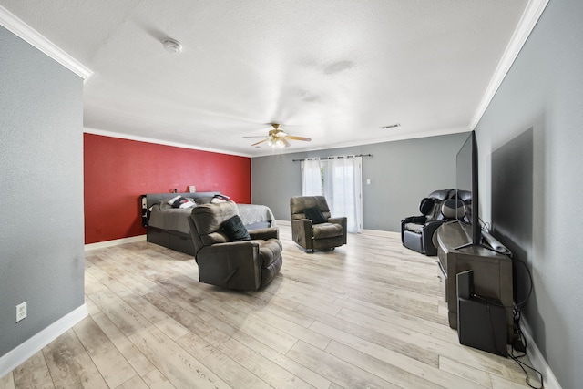 living area with wood finished floors, visible vents, a ceiling fan, and ornamental molding