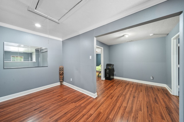 below grade area with wood finished floors, visible vents, crown molding, baseboards, and a textured ceiling