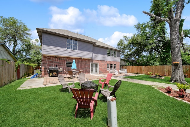rear view of house featuring a patio area, a fenced backyard, french doors, and brick siding