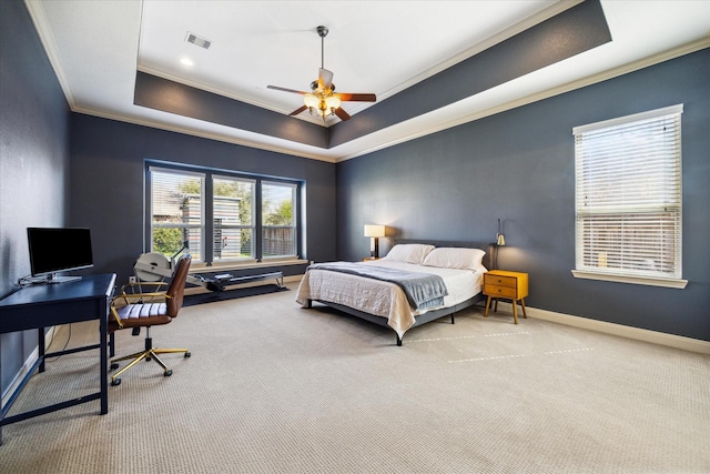 carpeted bedroom with crown molding, ceiling fan, a tray ceiling, baseboards, and visible vents