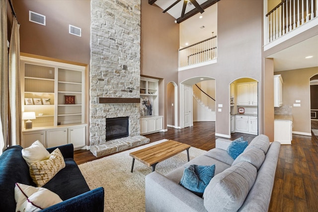 living area with arched walkways, a towering ceiling, and visible vents