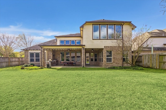 rear view of property featuring a fenced backyard, ceiling fan, and a lawn