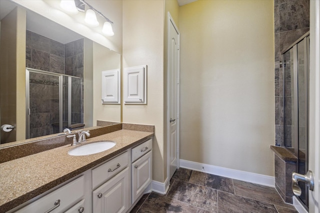 full bathroom with baseboards, vanity, and a stall shower