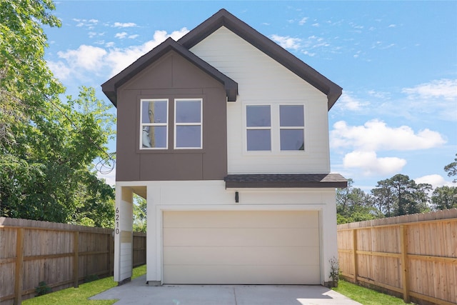 modern home with an attached garage, a shingled roof, a fenced backyard, and driveway