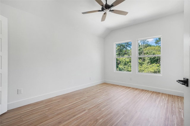empty room with light wood-style floors, lofted ceiling, a ceiling fan, and baseboards