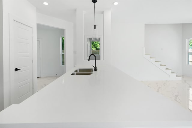 kitchen featuring a sink, recessed lighting, marble finish floor, pendant lighting, and light countertops
