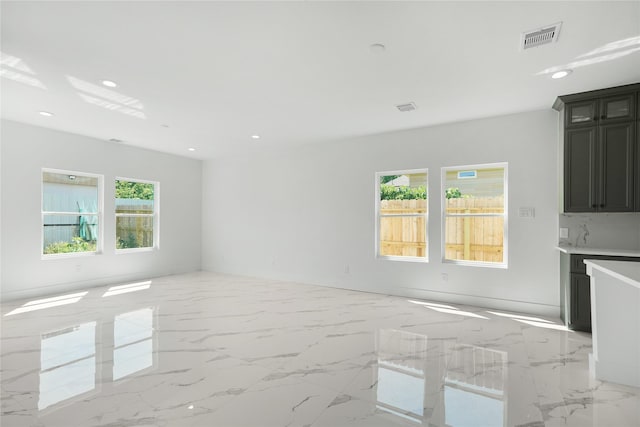 unfurnished living room featuring marble finish floor, visible vents, and recessed lighting