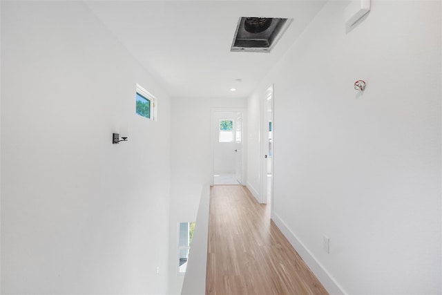 corridor featuring recessed lighting, light wood-style floors, and baseboards