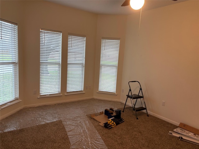 exercise room with plenty of natural light, a ceiling fan, baseboards, and carpet floors