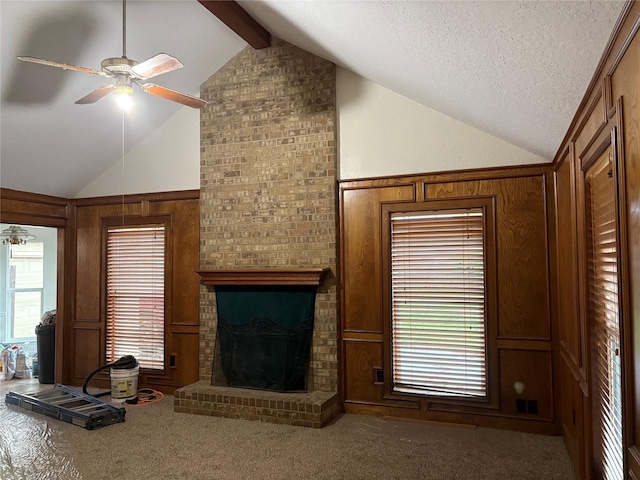 unfurnished living room featuring vaulted ceiling with beams, carpet floors, and a ceiling fan